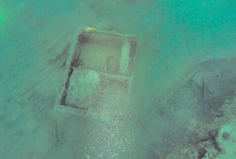 An empty ammo crate lies on the ship's deck